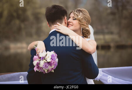 Getönten Schuss elegant Braut Bräutigam umarmt und an seinem Ohr flüstern Stockfoto