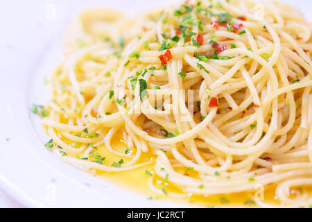 Leckere Pasta auf weißen Teller im Restaurant, traditionelle italienische Gerichte, leckere Spaghetti mit Paprika und Basilikum, wunderschöne mediterrane Küche Konzept Stockfoto