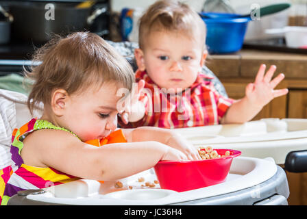 Zwei niedliche Babys essen Frühstück zusammen Stockfoto