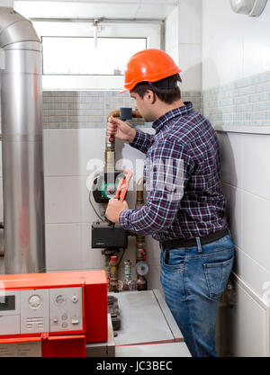 Professionelle Klempner in Schutzhelm Reparatur Heizung Stockfoto