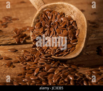 Leinsamen. Löffel mit Leinsamen auf hölzernen Hintergrund. Stockfoto