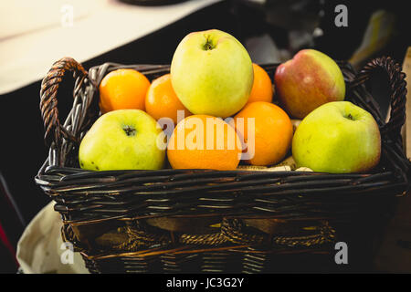Getönten Closeup Aufnahme von Korb voller Orangen und grünen Äpfeln Stockfoto