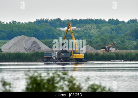 Bagger Sand und Kopfsteinpflaster in einem LKW auf einem See laden Stockfoto