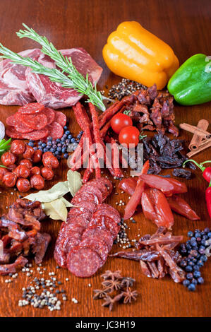 verschiedenen Wurst und Fleisch auf dem festlichen Tisch mit Gewürzen und Gemüse Stockfoto