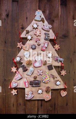 Handgemachte geschnitzte Weihnachtsbaum aus Holz dekoriert mit Lebkuchen. Stockfoto