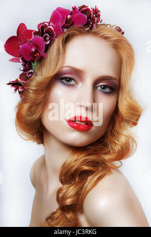 Exquisite Auburn Frau mit Kranz von Blumen und Bäumen Stockfoto