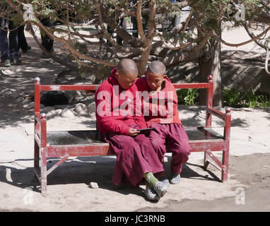 Zwei junge Mönche spielen auf einem Mobiltelefon in einem Kloster in Lo Manthang Nepal Stockfoto