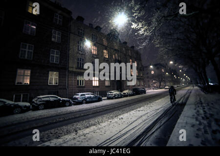 Ein Radfahrer fährt in der Nacht während eines Schneesturms, Kopenhagen. Kopenhagen hat rund 500 Kilometer Radwege und oft als die meisten Fahrrad-freundliche Stadt in der Welt rangiert. Stockfoto