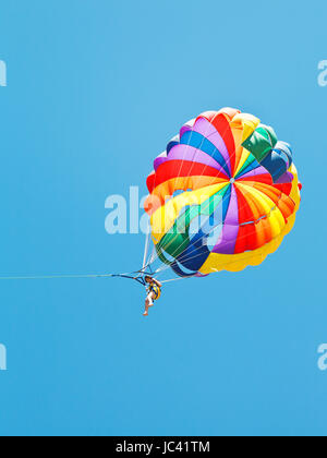 Mädchen Parakiting am Fallschirm in blauen Himmel im Sommertag Stockfoto