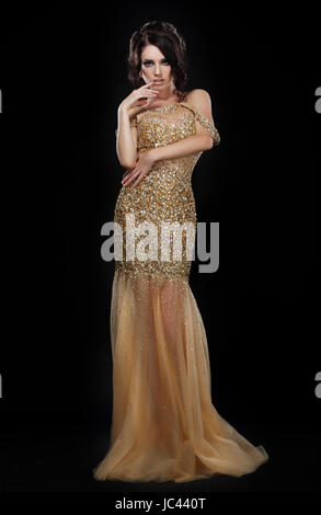 Formale Partei. Glamouröse Mode-Modell in eleganten goldenen Kleid in schwarz Stockfoto