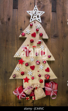 Dekoration: handgemachte geschnitzte Weihnachtsbaum mit roten und weißen Miniaturen. Stockfoto