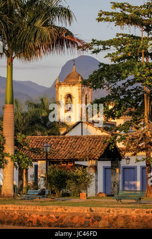 Abendstimmung in Kolonialstadt Paraty mit Igreja de Santa Rita, Kolonialbauten und tropischen Hügeln, Brasilien Stockfoto