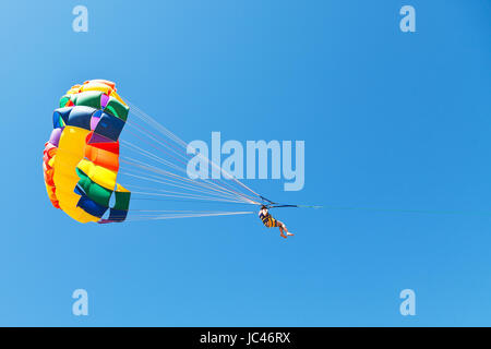 Frau parasailing am Fallschirm in blauen Himmel im Sommertag Stockfoto