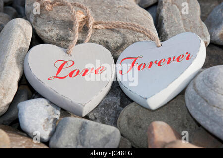 zwei hölzerne Liebe Herzen auf den Felsen an einem Strand Stockfoto