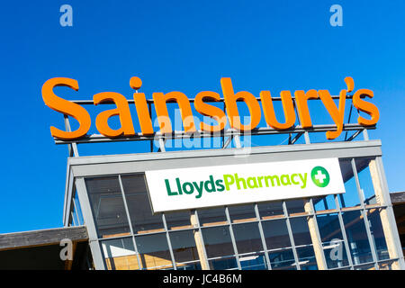 Ein Zeichen für Sainsbury's und Lloyds Pharmacy auf einem großen Sainsbury's Supermarkt in King's Lynn, Norfolk. Stockfoto