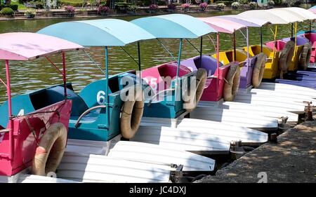 Reihe von bunten Wasserkreislauf Boote oder Tretboote am Dock in einem Park. Stockfoto