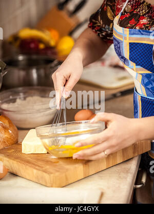 Nahaufnahme Foto Frau Mischen von Eiern in Glasschale Stockfoto