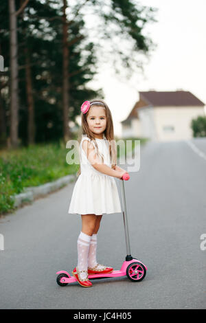 schöne Mädchen mit Roller unterwegs Stockfoto