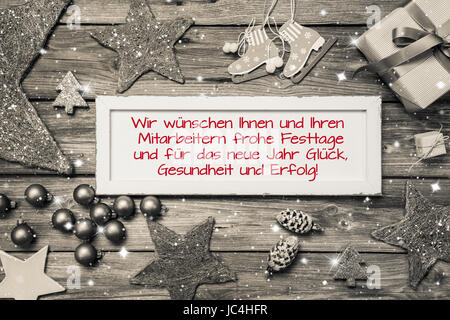 Grußkarte für Weihnachten mit deutschem Text für Frohe Weihnachten. Idee für Mitarbeiter und Kunden in roten Schriften. Stockfoto