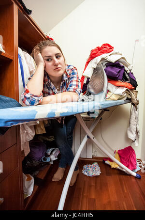 Closeup Portrait der depressive Hausfrau gelehnt Bügelbrett Stockfoto
