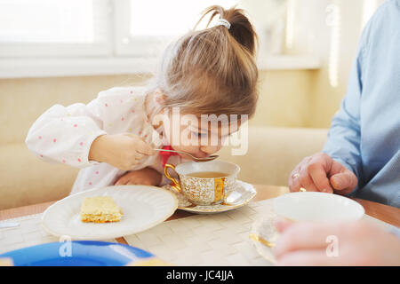 kleines Mädchen trinkt Tee am Morgen Stockfoto