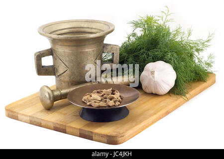 Still Life-Gewürze, Bengal Cardamoms, Ringelblume Staminas in Kupfer Vase auf einem Holzbrett auf einem Hintergrund von einem stern Stupa zum Mahlen von Gewürzen, bunche Stockfoto