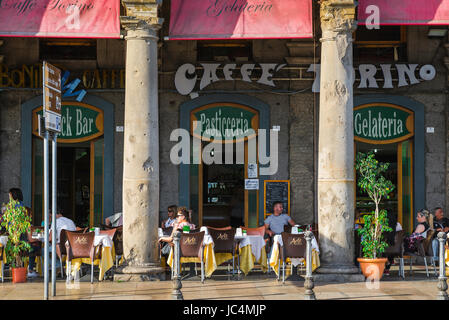 Cagliari Via Roma, Blick auf die Menschen, die sich im Sommer an Tischen auf einer Arkadenterrasse außerhalb des Caffe Torino im Marina-Viertel von Cagliari entspannen, Stockfoto