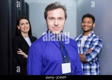 Gut aussehend ernste Mann stand vor seinen Kollegen Stockfoto