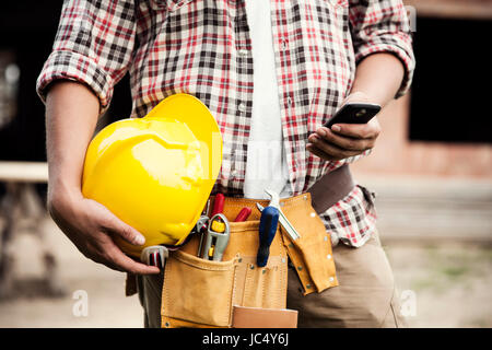 Nahaufnahme der Bau Arbeiter SMS auf Handy Stockfoto