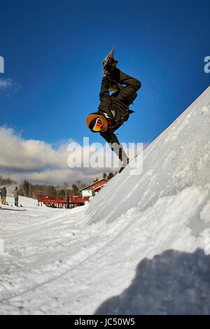 Ein Snowboarder ein Handplant auf ein Feature in der Terrainpark zu tun. Stockfoto