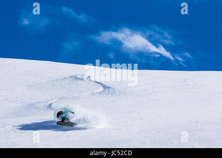 Profi-Snowboarder und 2014 reitet Olympiasieger, Jamie Anderson, Neuschnee an einem sonnigen Tag beim Snowboarden in Haines, Alaska. Stockfoto