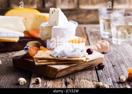 Käse und Wein-Party Tisch, perfekten Urlaub Vorspeise auf rustikalem Holzbrett Ziegenkäse mit Cracker Stockfoto