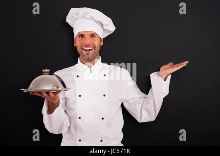 Lächelnd Chef empfohlen Hauptgericht Stockfoto