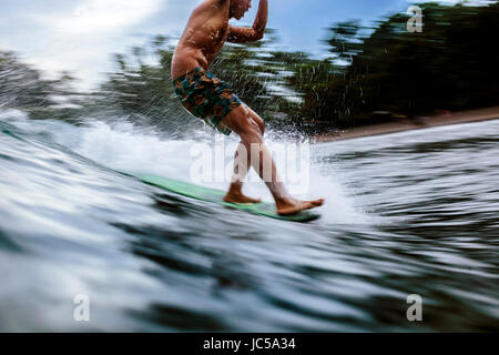 Männliche Surfer auf der Welle Stockfoto