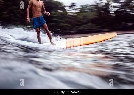 Männliche Surfer auf der Welle Stockfoto