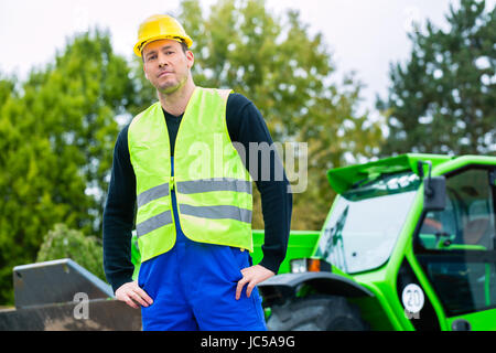 Builder oder Fahrer stand vor Baumaschinen auf der Baustelle Stockfoto