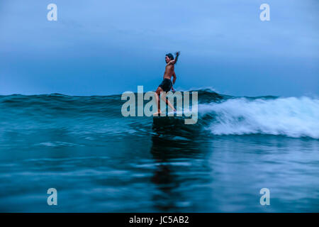 Männliche Surfer auf der Welle Stockfoto