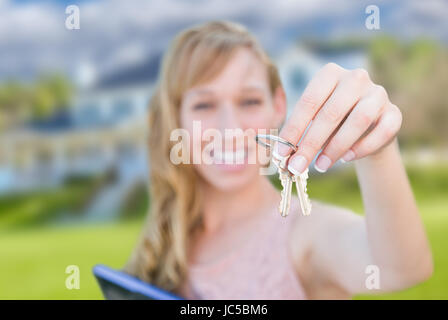 Frau mit Hausschlüssel vor schönes neues zu Hause begeistert. Stockfoto