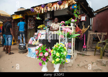 Eine weibliche Ladeninhaber außerhalb ihres Shop, Nigeria, Afrika Stockfoto
