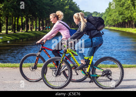 Zwei junge Frauen auf einem Radweg im Garten, Kassel, Deutschland Radfahren, Europa Deutschland Radfahrer Frauen Stockfoto