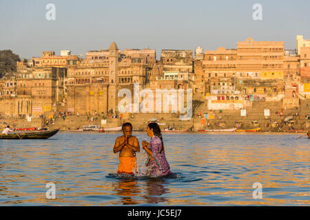 Pilger sind mit Badewanne und Beten auf den Sandbänken am heiligen Fluss Ganges, Panorama der Dashashwamedh Ghat, Main Ghat, in der Ferne Stockfoto