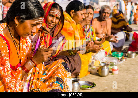 Eine Gruppe der weiblichen Pilger ist ein religiöses Ritual, das auf den Sandbänken am heiligen Fluss Ganges Stockfoto