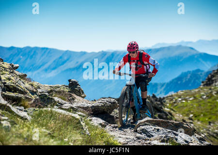 Ein Mountainbiker fährt mit einem Gebirgskamm in Andorra in den Pyrenäen. Stockfoto