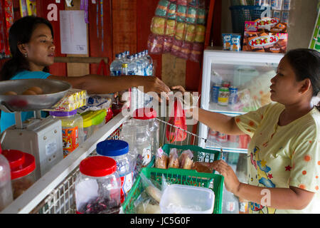 Ein Frauen dient ein Kunde in ihrem Shop, Indonesien, Asien. Stockfoto