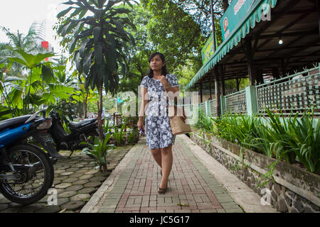 Eine Frau zu Fuß entlang der Straße, Indonesien, Asien. Stockfoto