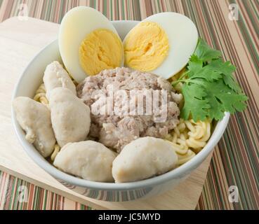 Küche und Essen, asiatische Ramen Instant-Nudeln mit Schweinefleisch, Fleisch Ball und gekochtes Ei in weiße Schüssel. Stockfoto