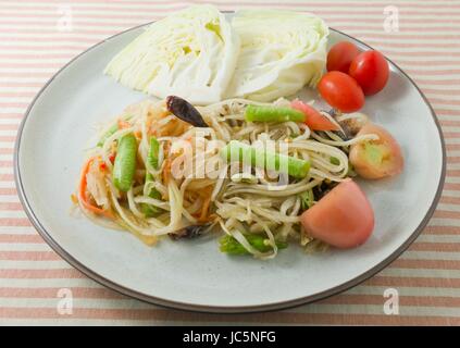 Thai-Küche und Essen, Thai traditionelle Som Tam oder grüne Papayasalat mit roher Papaya, Tomaten, Yardlong Bohne, Chili, Erdnüssen und Kalk. Stockfoto