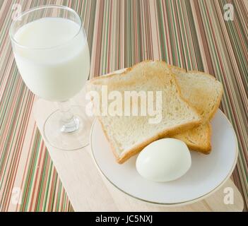 Küche und Essen, Frühstück mit braunen Toast, gekochten Eiern und Milch. Stockfoto