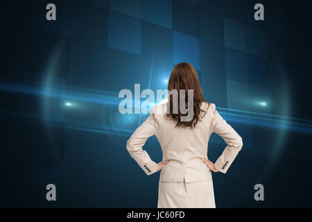 Zusammengesetztes Bild der Geschäftsfrau zurück zu Kamera mit Händen auf den Hüften stehen Stockfoto