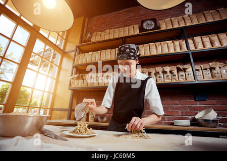 Frau mit Nudeln in café Stockfoto